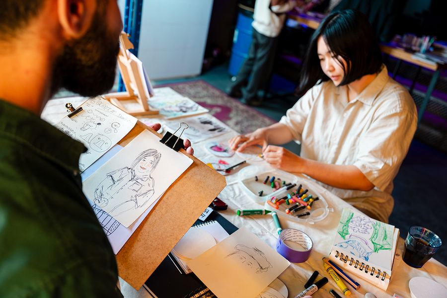Artist drawing a live portrait station at an event