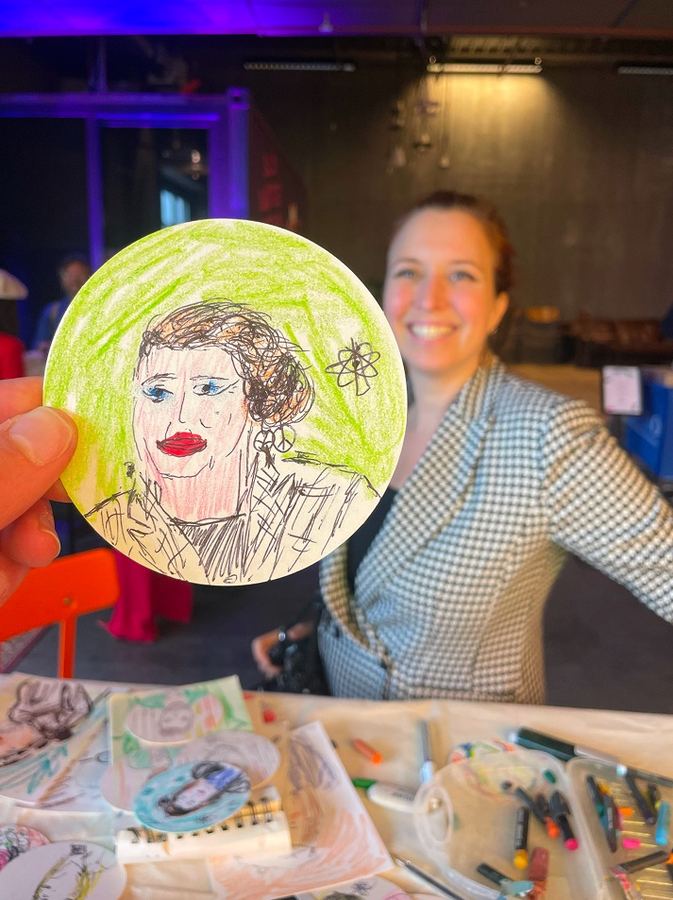 Guest holding a colorful portrait drawing